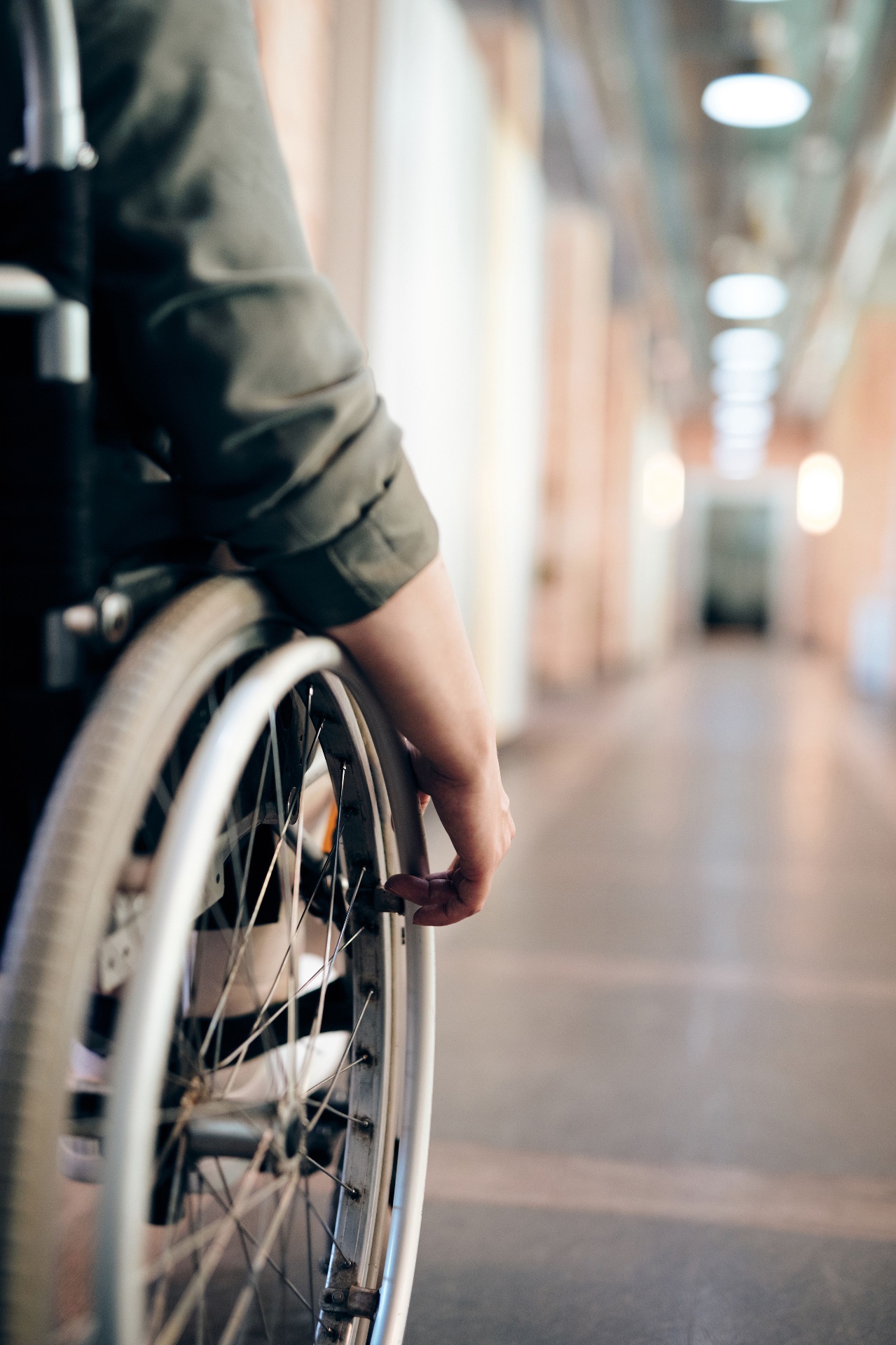 Wheelchair user moving independently through an accessible hallway